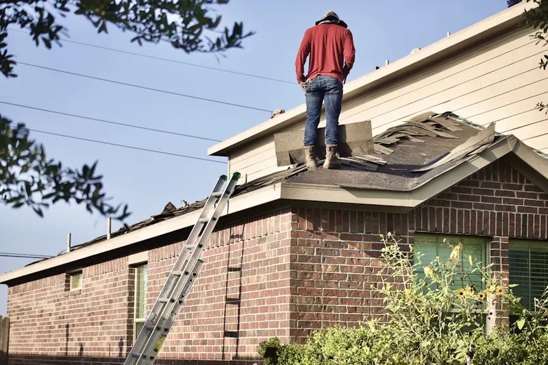 Professional roofer working on a residential roof in Lenox